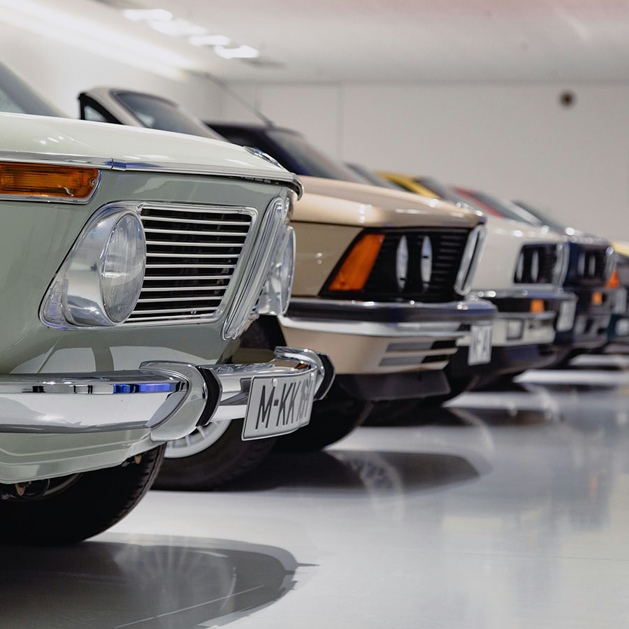 Row of colorful vintage cars in museum.
