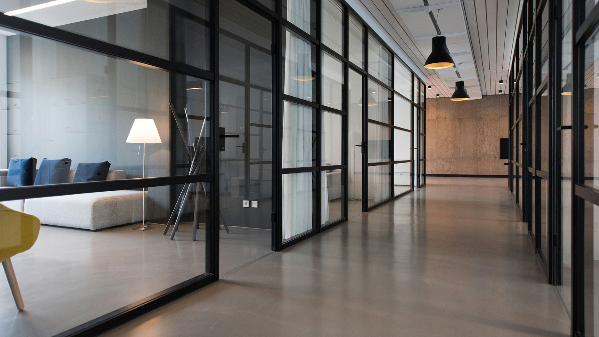 Office space with glass walls and comfortable seating.